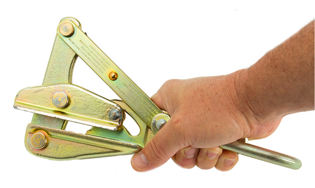 A hand grips the PK Safety Supply Test Product 2, a metallic wire strainer or tensioner tool with multiple pivot points and bolts, designed for tightening and securing wire fencing.