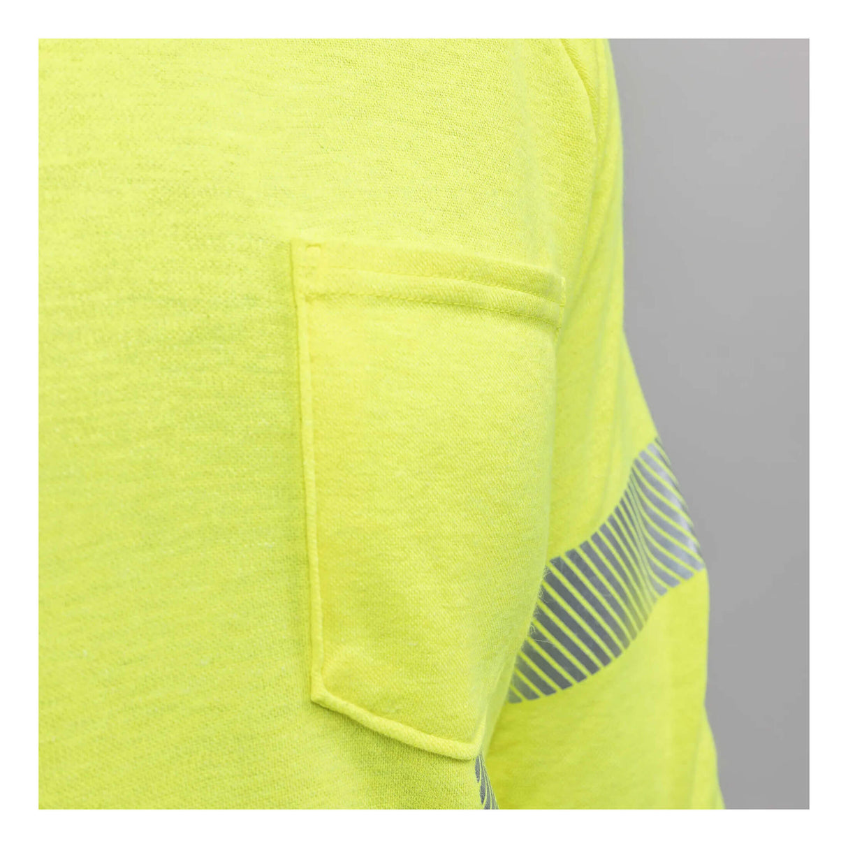 Close-up of the NSA DRIFIRE Helix FR Long Sleeve Hi-Vis T-Shirt Class 3 TEE-HXC3 sleeve, highlighting a small pocket and reflective silver stripe, set against a plain gray background.