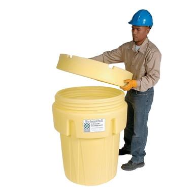 A person wearing a blue hard hat and gloves is removing the lid from a large UltraTech Overpack Plus Salvage Drum 058_, which is yellow in color. The drum features a label on the front. Dressed in a beige shirt and dark pants, they seem prepared for spill response, standing against a white background.