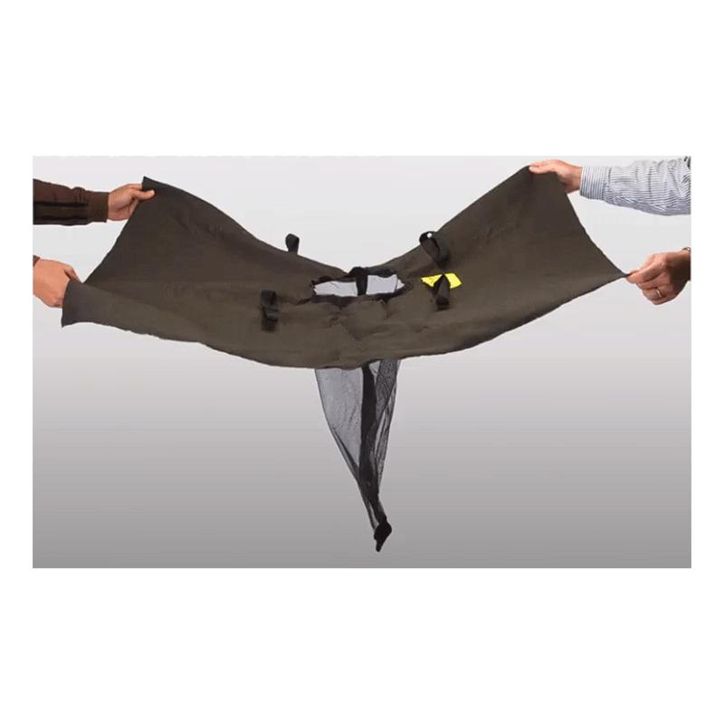 Two individuals stretch a dark green fabric featuring attached straps and a mesh section, akin to the UltraTech Trash and Debris Drain Guard 922 by UltraTech International, designed for sediment removal efficiency in stormwater waste management, against a plain background.