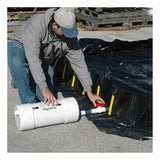 A person in a gray hoodie and cap is adjusting an UltraTech International UltraTech Self Bailer 99_ _, a white cylindrical container with a connected pipe, next to a black tarp on a concrete surface. The setup appears to be part of efforts related to stormwater filtration or hydrocarbon removal tasks.