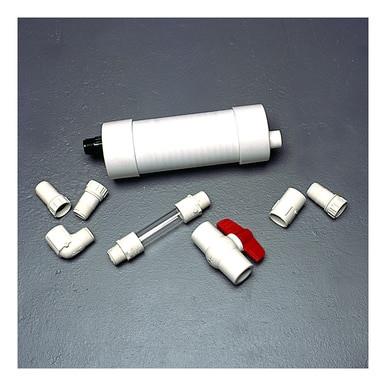 On a gray surface lies the disassembled UltraTech Self Bailer 99_ _ by UltraTech International, an excellent choice for stormwater filtration. This set includes a white cylindrical filter, several white plastic connectors, a transparent tube, and a valve with a red handle. It is ideal for use in hydrocarbon removal systems.