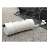 An UltraTech Self Bailer 99 from UltraTech International, a white cylindrical tank, is positioned on a concrete surface and linked by pipes to a black tarp or barrier. These pipes are fitted with red and white connectors, indicating an advanced system for stormwater filtration designed for efficient hydrocarbon removal.