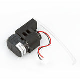 Image of a compact black peristaltic pump from the BW Honeywell Replacement Pump Kit XT-RPUMP-K1 by PK Safety Supply, featuring a white plastic tube and two wires—one red and one white. A white label with text is wrapped around the body of the pump.