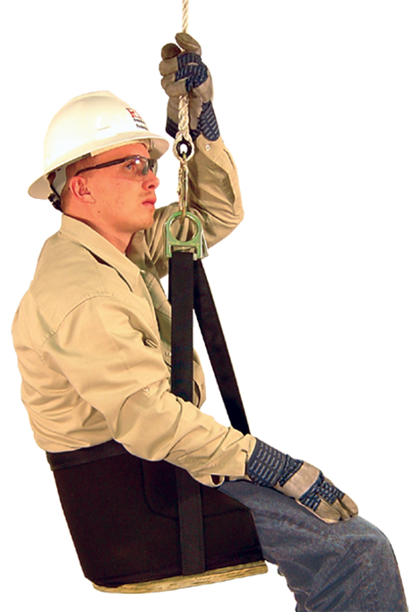 A person, equipped with a hard hat, safety glasses, and gloves, sits confidently in a French Creek Deluxe Work Seat 4153 by French Creek Production. Wearing a beige shirt and jeans, they seem prepared for work at height or in a safety training environment, highlighting strong fall protection measures.