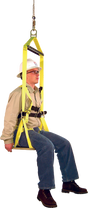 A person wearing a safety helmet and glasses sits comfortably in the French Creek Bosun Chair Work Seat 4154, which is attached to a rope. Sporting a beige shirt, blue jeans, and brown boots, they seem to be demonstrating fall protection equipment from French Creek Production that is perfect for tasks such as window washing.