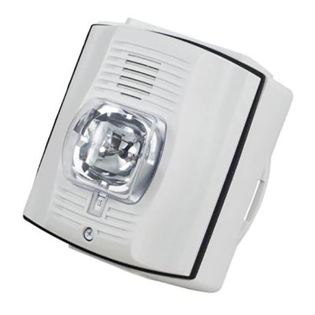 A white RKI 2Wire Strobe/Horn with a clear, protruding lens is mounted on the wall. It features ventilation slots and a small indicator at the bottom, similar to a SpectrAlert system from RKI Instruments, providing comprehensive safety and reliability in any setting.