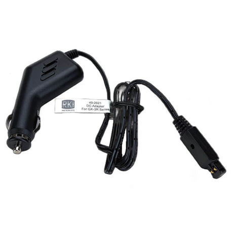 A black RKI Instruments car charger with a coiled cable comes equipped with a vehicle plug designed for the RKI GX-3R and GX-3R Pro models. The label identifies it as the "RKI GX-3R & GX-3R Pro 12-24 VDC Adapter w/Vehicle Plug 49-2021.