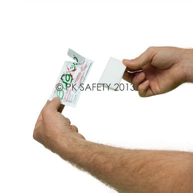 A person tearing open a small packet of a Hydrochloric Acid Spill Clean Up Kit, displaying text and a partially visible red and green symbol reminiscent of the Coretex BugX30 Deet Insect Repellent Towelettes branding. The background is white.