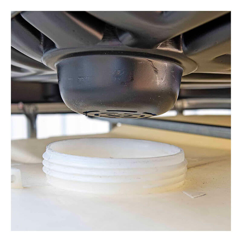 A close-up shows the black valve or nozzle of the UltraTech IBC Funnel 0648 by UltraTech International, positioned above a large white plastic container. The nozzle seems to be part of a chemical-resistant dispensing or storage system, likely used for handling liquids in an industrial environment.