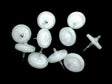 A scattered group of round, white items with transparent tops and metal points, similar to RAE Systems 45 mm External Filters (10/Pack, Product Code 002-3022-010), set against a black background.