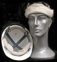 A gray mannequin head wears a safety helmet featuring a cushioned interior and an OccuNomix MiraCool Terry Toppers Hard Hat Sweatband. Beside it, another helmet rests upside down, showcasing its cushioned inside. The dark background highlights the helmets and their liners.