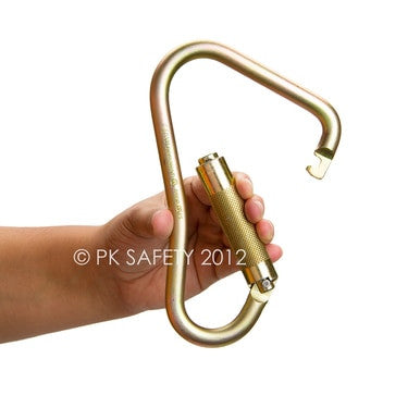 A hand grips the Skylotec Steel Scaffold Hook Carabiner H-143, a large, golden-colored carabiner with a textured, rotating locking mechanism ideal for fall protection. The text "PK Safety 2012" is visible. Designed for climbing safety by Skylotec, this steel scaffold hook features a large gate opening for secure attachments.