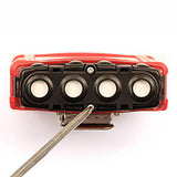 The RKI Instruments GX-2009 MSHA 4-Gas Confined Space Monitor (model 72-0314-MSHA-C) resembles a red and black belt buckle with four round white spots resembling eyes, accompanied by a pointed metal object inserted into a slot below.