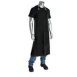 A mannequin displays the PIP Neoprene Black Apron 200-12501 from PIP - Protective Industrial Products over a black shirt, blue jeans, and black shoes. The apron is secured around the neck and waist for enhanced chemical protection, creating a striking contrast against the white background.