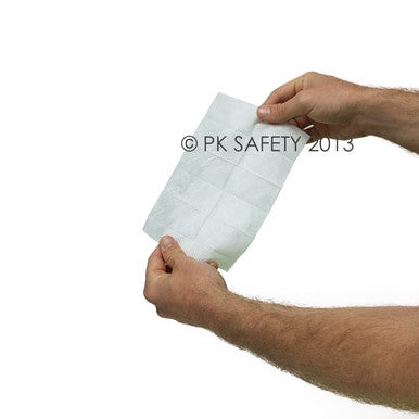 A person holds a rectangular Coretex BugX30 Deet Insect Repellent Towelette against a plain white background.