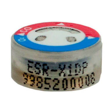 The image shows a detailed view of a compact cylindrical item, similar to the RKI Replacement CO/O2 Sensor ESR-X1DP-CX. The top displays red and blue hues, and the side is marked with "ESA-X1DP" followed by numerical digits. Its round shape indicates it is part of a Dual Sensor Combo design from RKI Instruments.