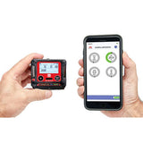 Two hands holding devices showcase cutting-edge technology. The left hand grasps an RKI GX-3R Pro Gas Confined Space Monitor by RKI Instruments, featuring a digital display for electronic gas monitoring, while the right hand holds a smartphone utilizing Bluetooth communication to display an app with circular gauges. Both devices present precise numeric data for personal monitoring.