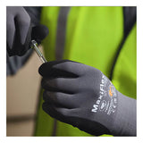 A person in a yellow safety vest is holding a screw or bolt with both hands while wearing PIP ATG MaxiFlex Ultimate Micro-Foam 3/4 Coated Palm Nitrile Gloves (34-875).