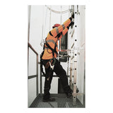 A worker in safety gear climbs a vertical metal ladder equipped with the Frontline Ladder Cable Vertical Lifeline System VLCS by Frontline Fall Protection, ensuring fixed ladder safety in an industrial setting.