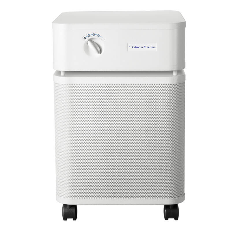 The Austin Air Systems Bedroom Machine B402 is a white air purifier with a perforated front panel, control dial, military-grade HEGA filter, and four black caster wheels for easy mobility.