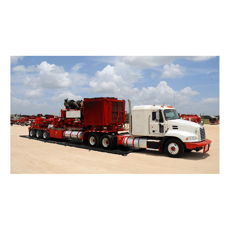 A large white and red flatbed semi-truck transporting industrial equipment and an UltraTech Foam Wall Model Containment Berm is parked on a dirt lot beneath a partly cloudy sky.